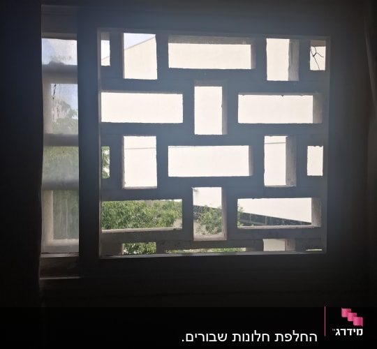 חלון עם מסגרת דקורטיבית ותצפית לנוף חיצוני
